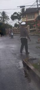 Tertangkap Kamera ! Mesti Diguyur Hujan, Aipda Deni Meydistira Personil Satlantas Polres Lamsel Tetap Semangat dan Aktif Mengatur Lalu Lintas