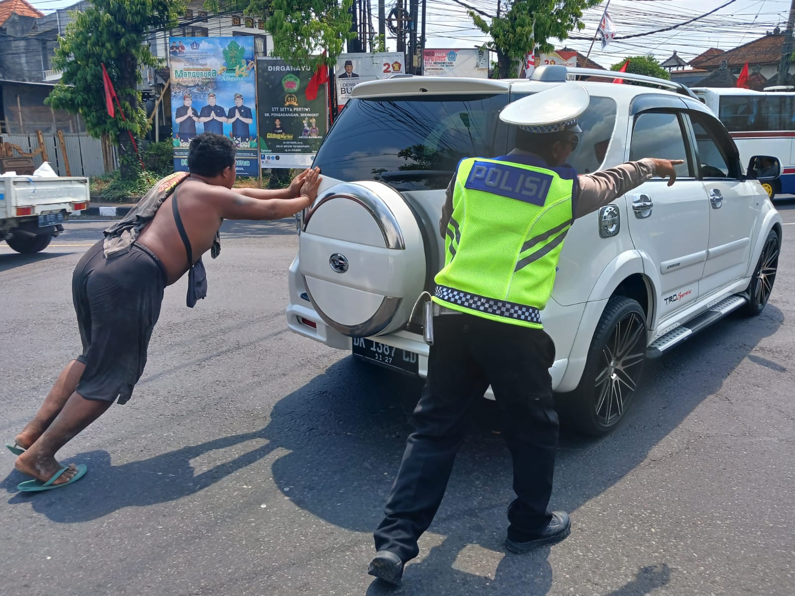 Anggota Lantas Polsek Mengwi Bantu Warga Dorong Mobil Mogok