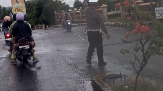 Tertangkap Kamera ! Mesti Diguyur Hujan, Aipda Deni Meydistira Personil Satlantas Polres Lamsel Tetap Semangat dan Aktif Mengatur Lalu Lintas